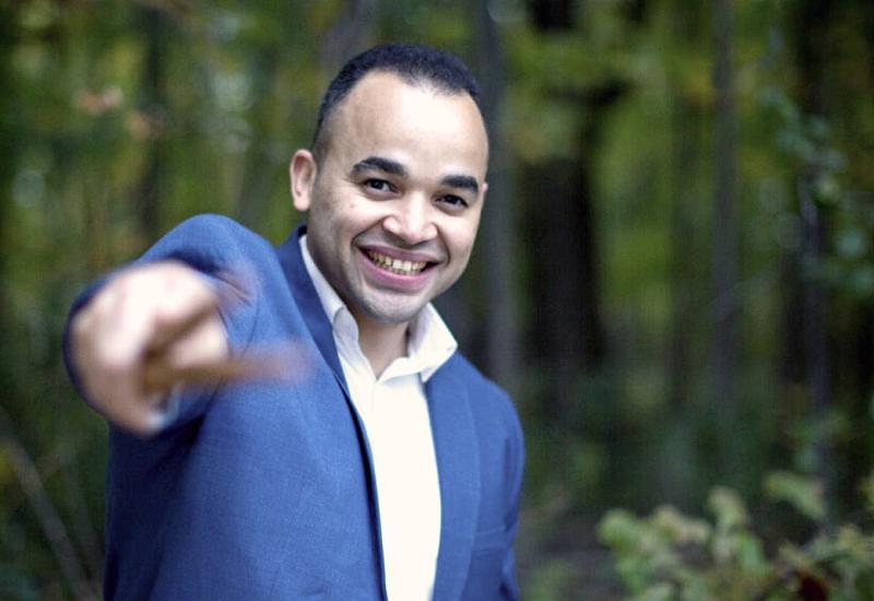 Jean Carlo Ureña Gonzalez standing in woods and pointing at viewer with drum sticks