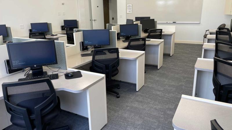 Computer lab with individual computing desks, view from the back of the room.