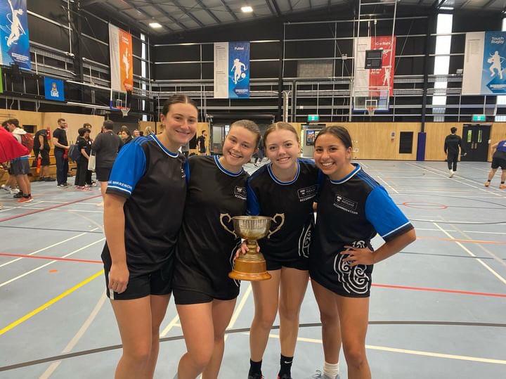 Mackenzy Dreher, Maya Alberts, Natalie Linebarger, and Sophia Morin hold a trophy while competing in New Zealand.