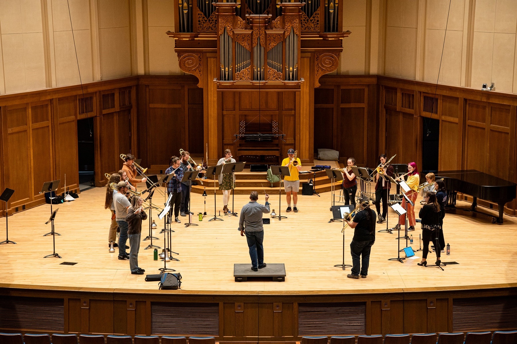 Flute and trombone ensembles rehearse on the stage of Memorial Chapel.