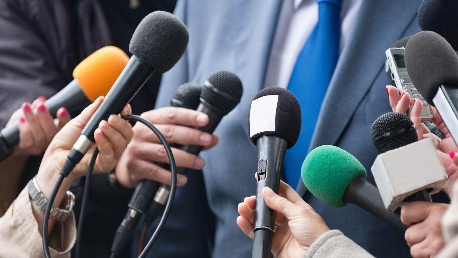 Mics held up to person wearing a suit