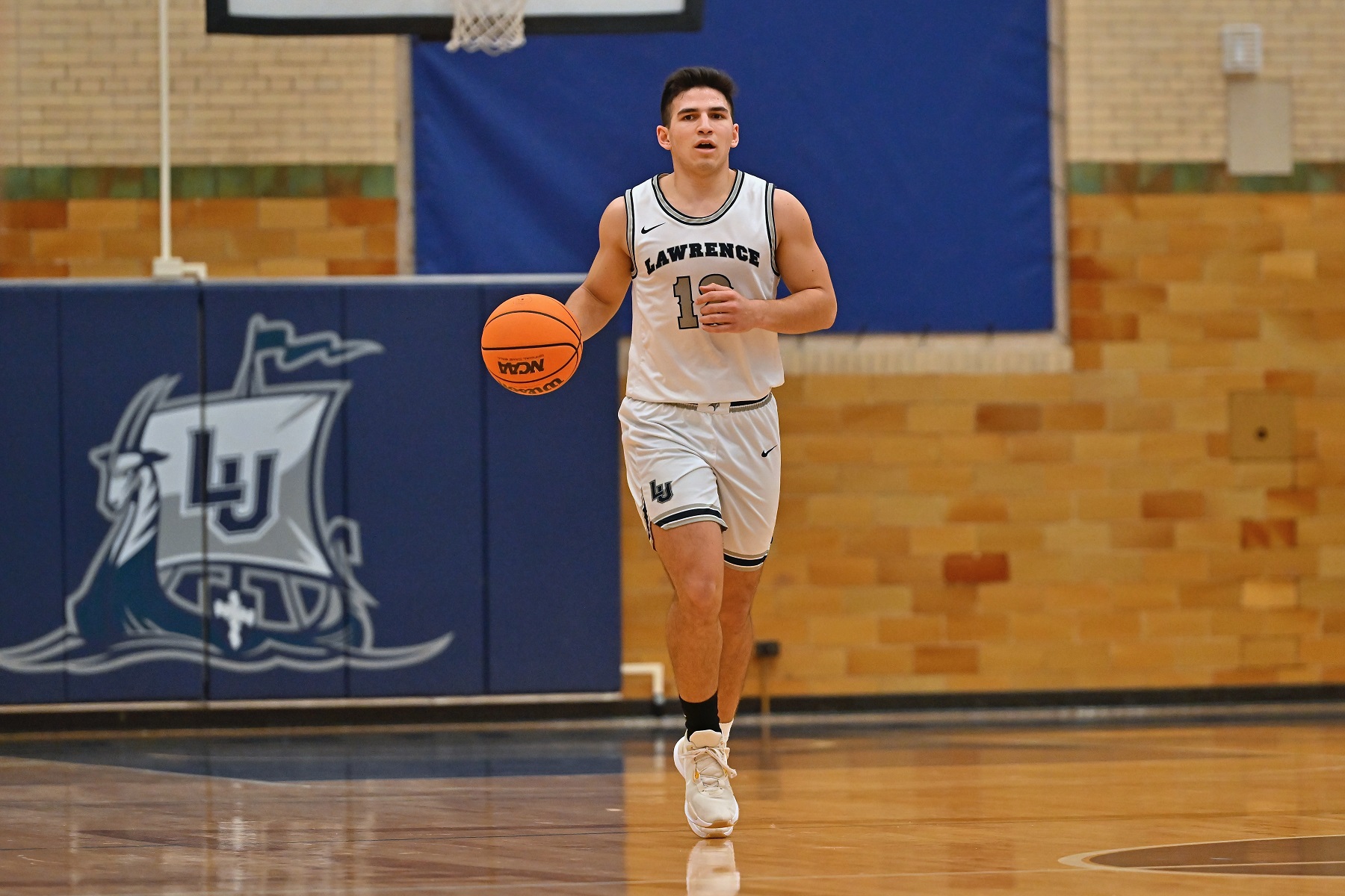 Nico Manzanera dribbles the ball in a basketball game at Alexander Gym.