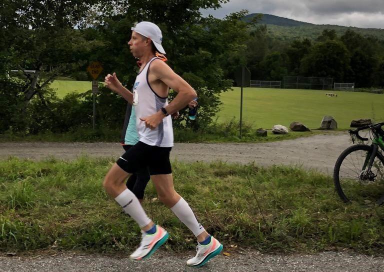 Jim Miller ’80, running outside surrounded by greenery.