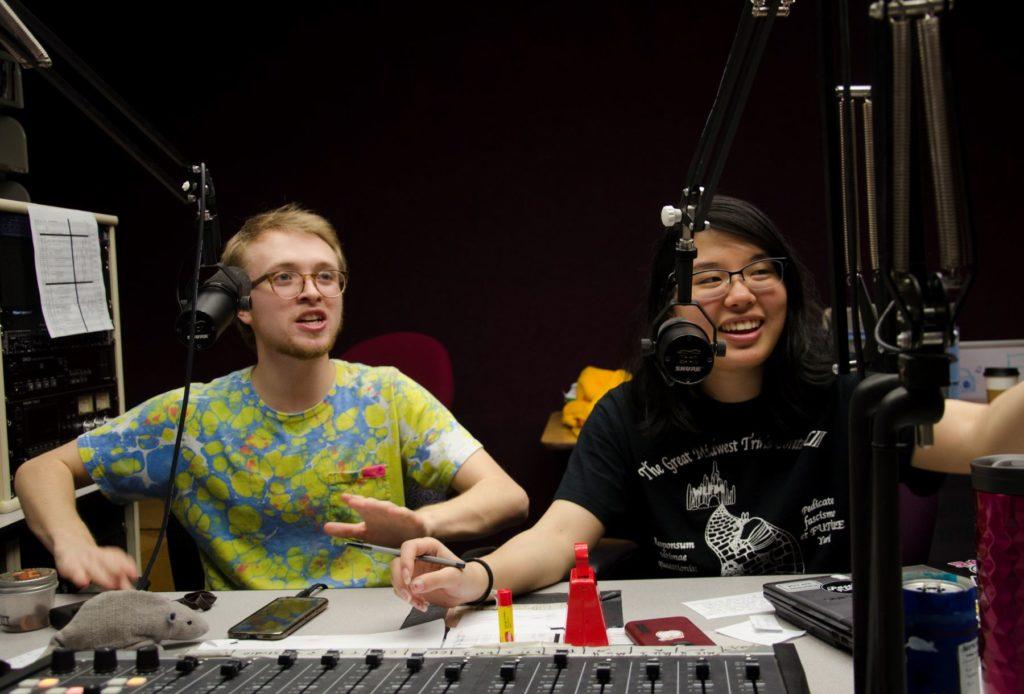 two students smiling behind microphones at WLFM