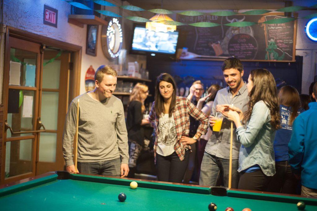 Students playing a game of 8 ball in the viking room