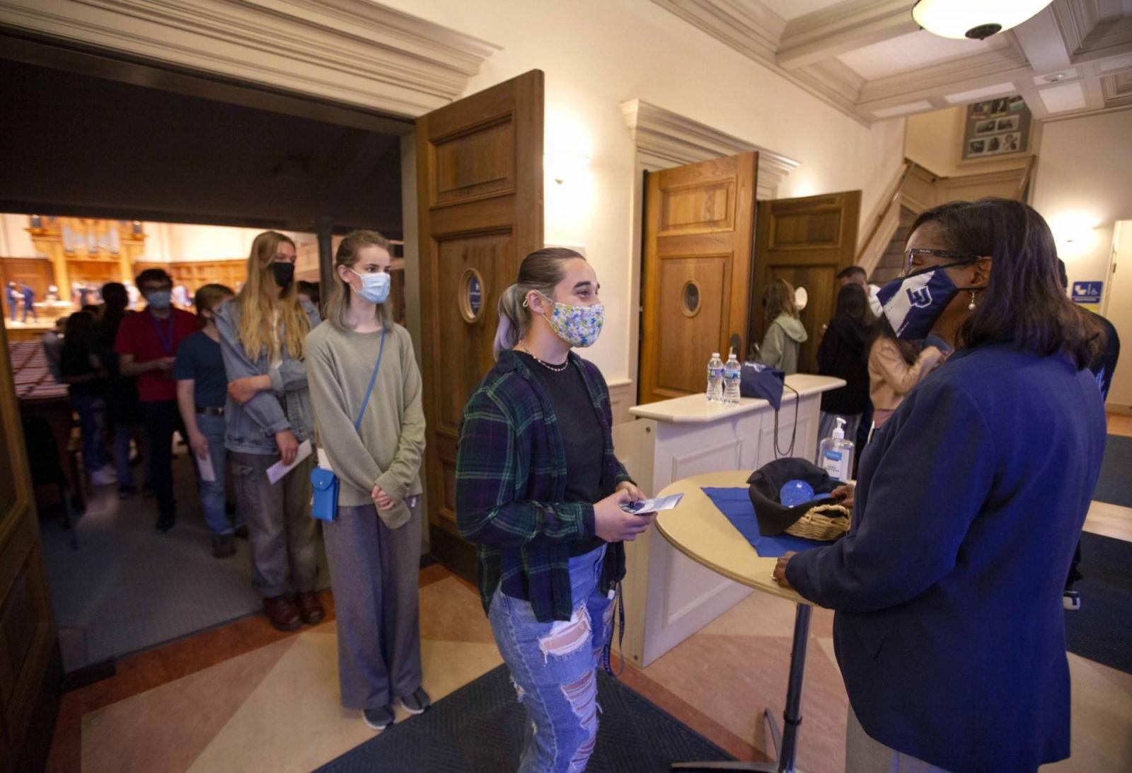 Laurie Carter, the university president, greets students during the President's Handshake in Memorial Chapel.