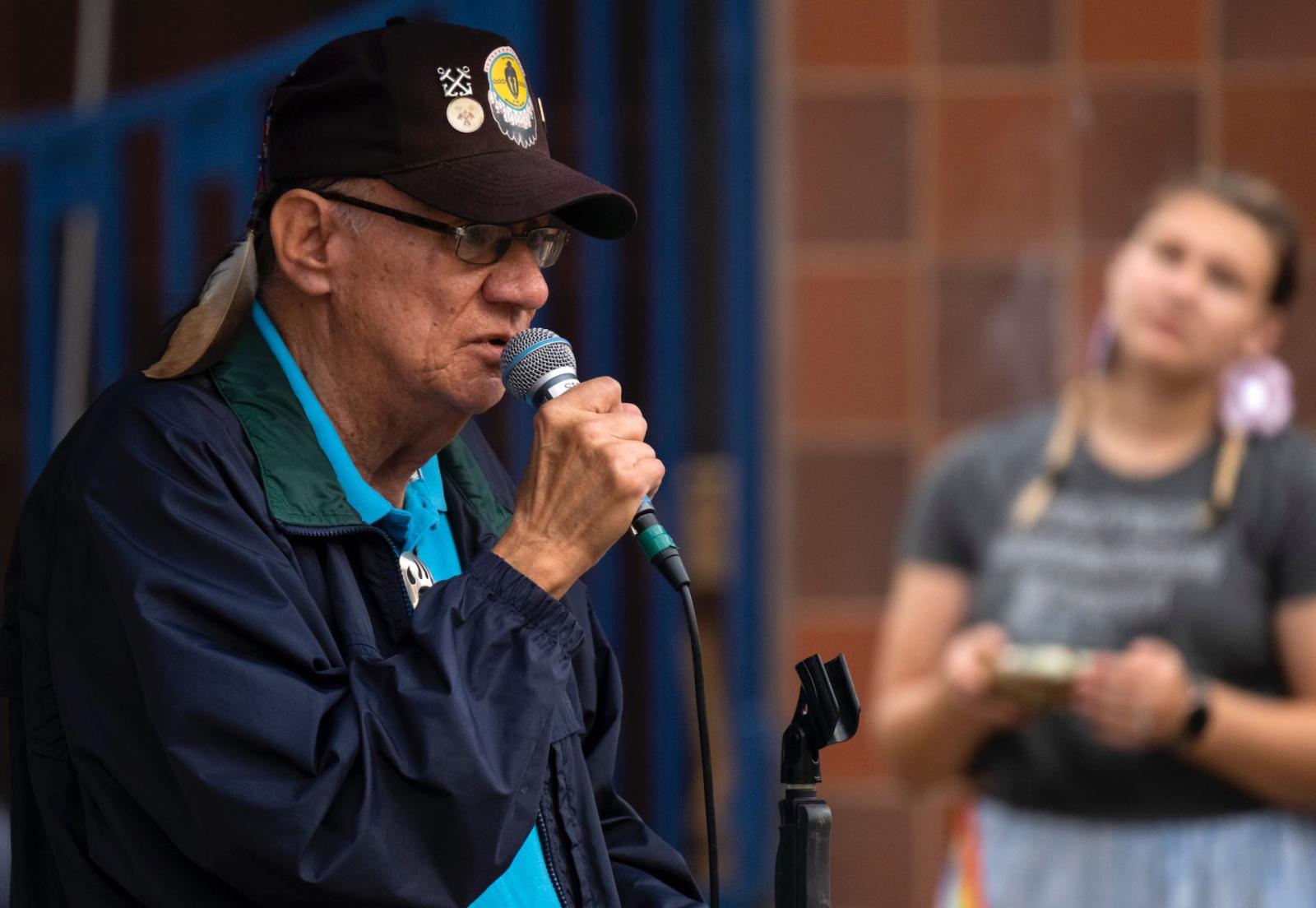 Dennis Kenote, a Menominee elder speaks with microphone in hand during Lawrence's celebration of Indigenous Peoples' Day.