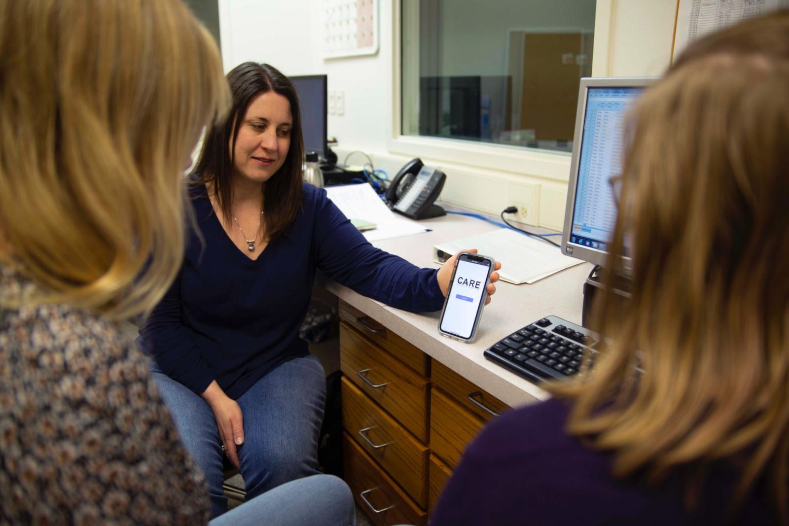 Lori Hilt sharing app with colleagues in her office.