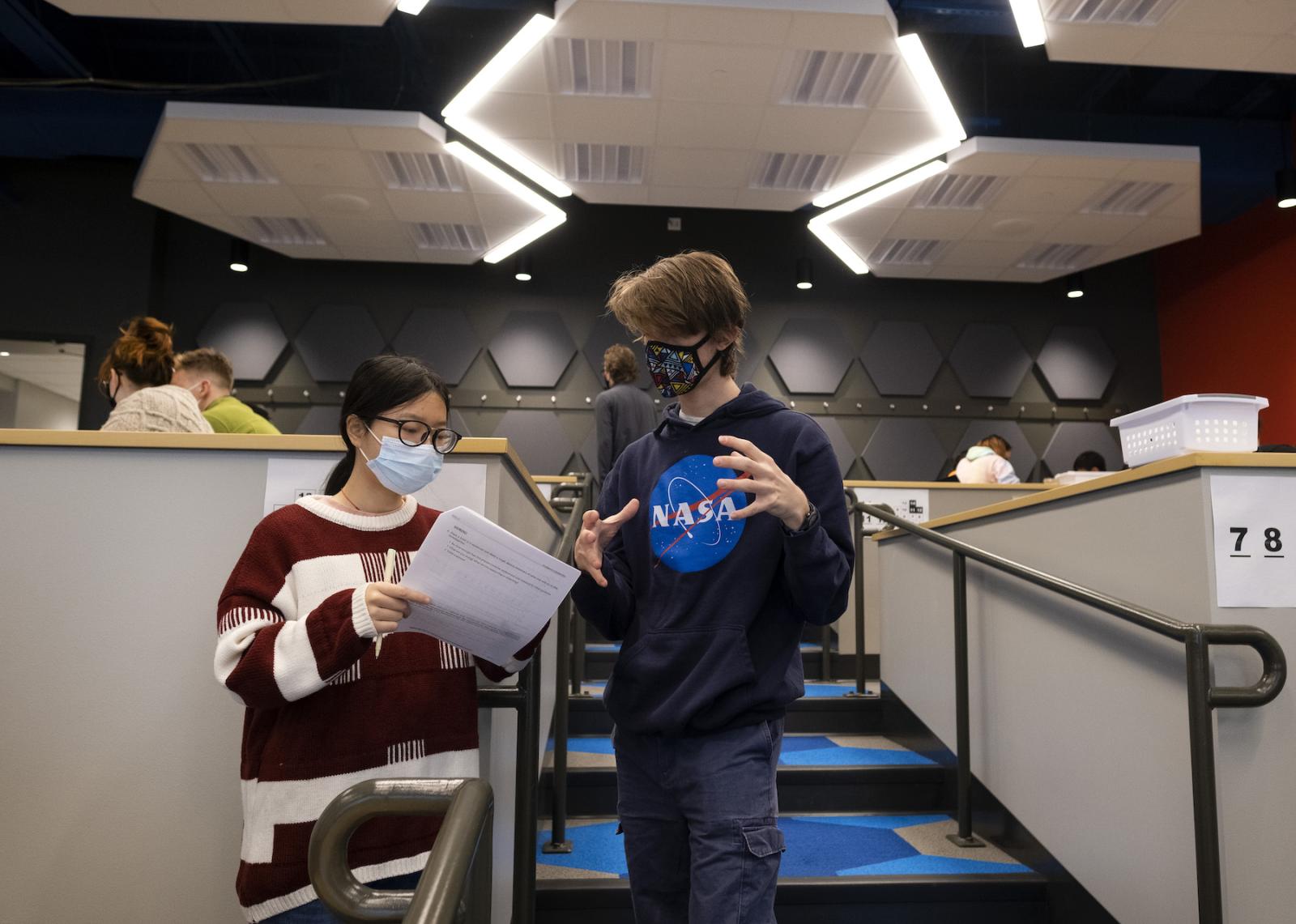 Two students collaborating and working on an assignment during an Introduction to Physics class.