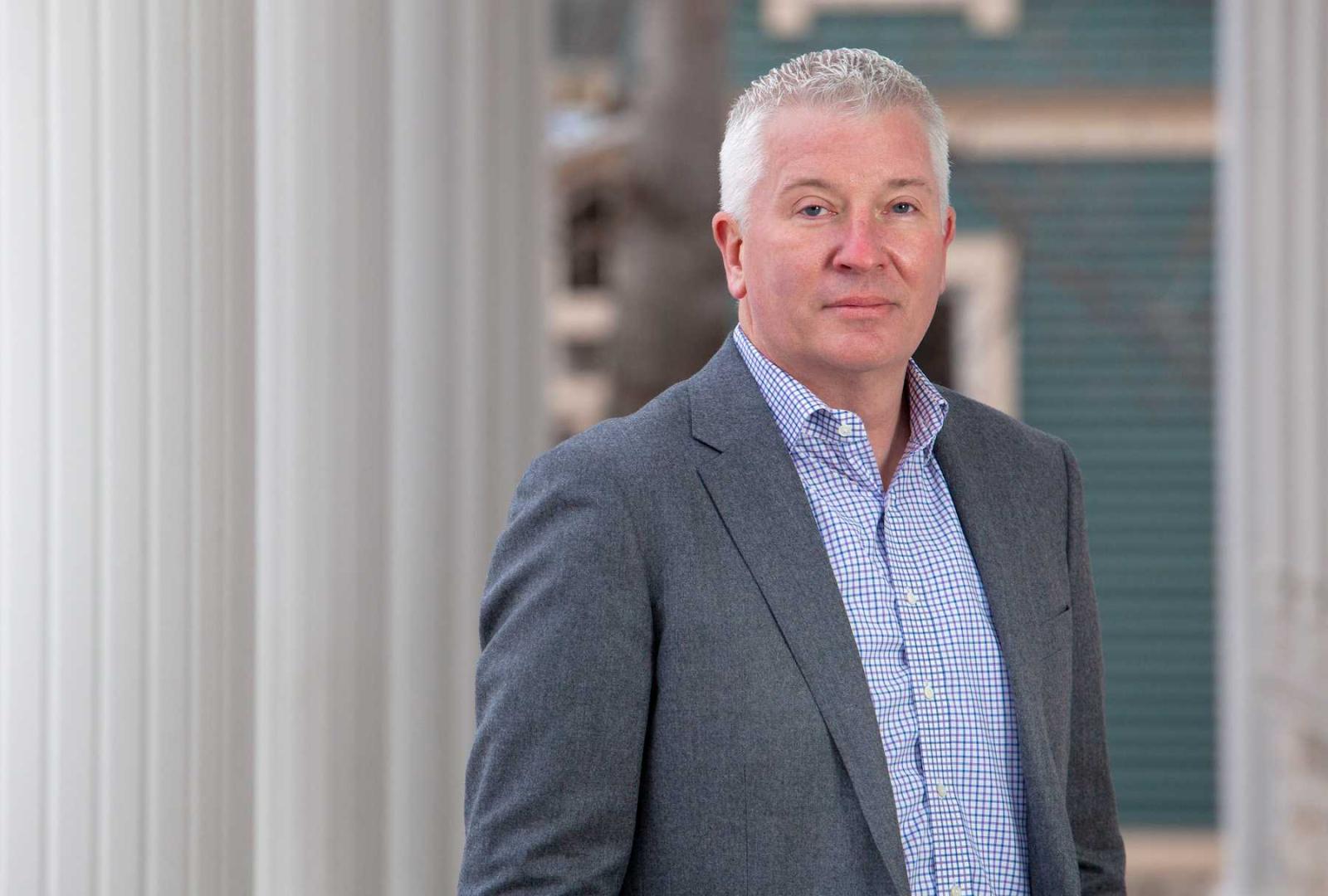 Chris Clarke poses for a photo in front of Sage Hall.