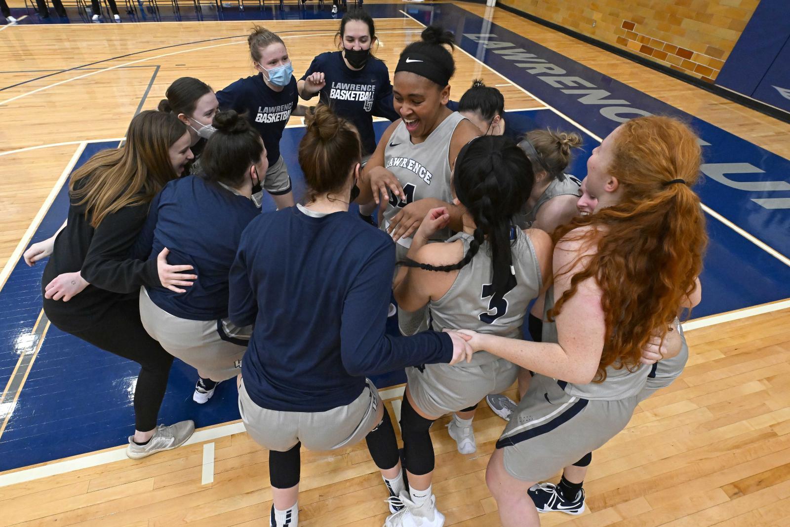 Kenya Earl is surrounded by teammates after breaking the basketball scoring record.