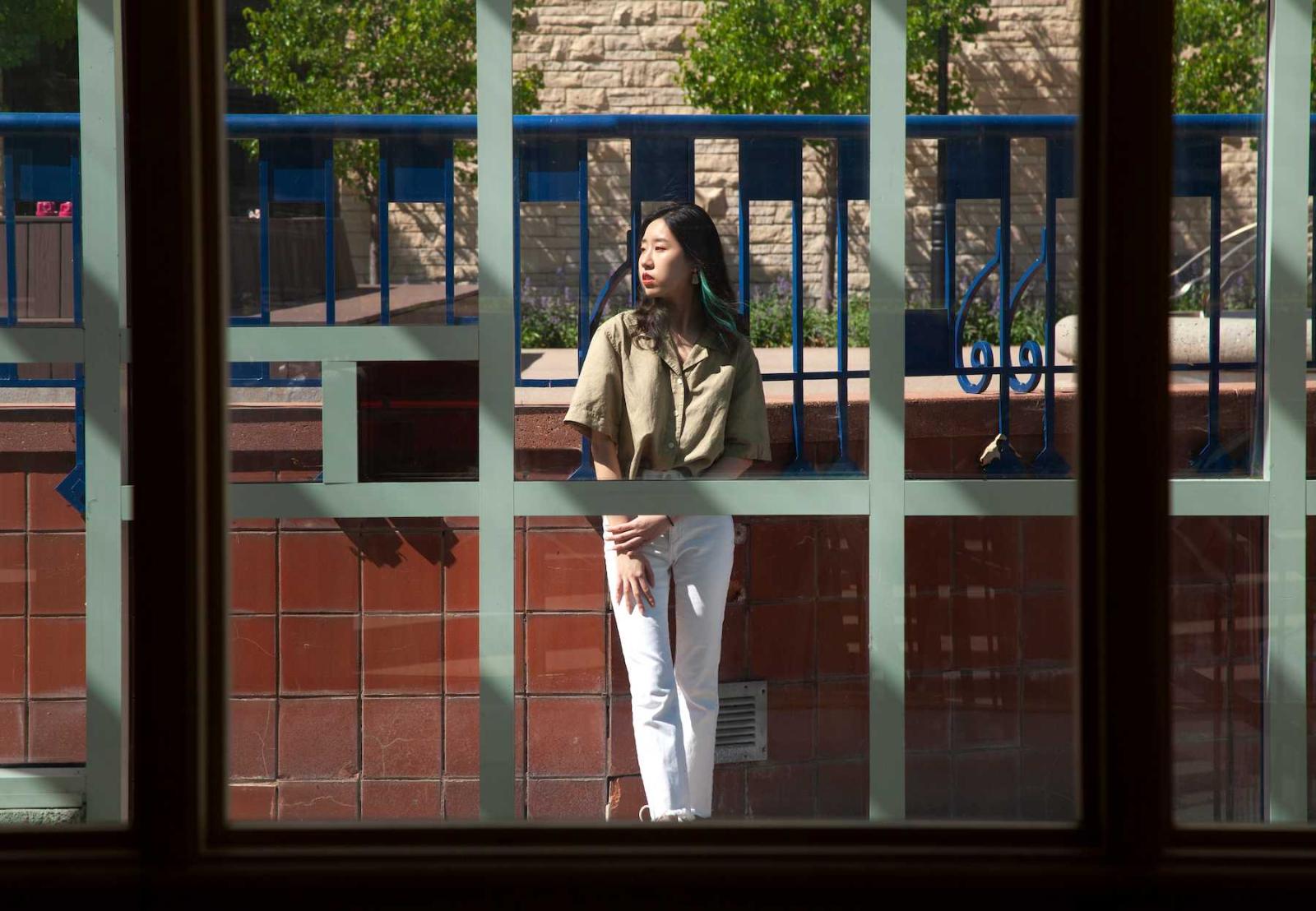 Jin Han stands beside the Wriston Art Center.