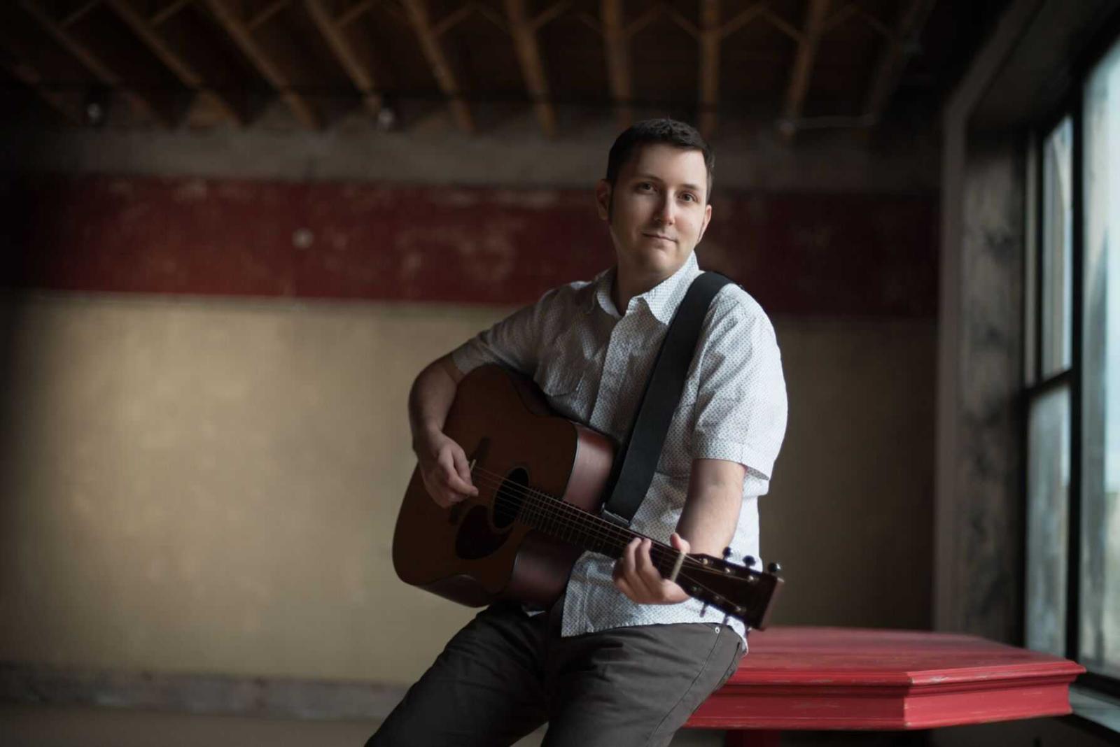 Portrait of Zachary Scot Johnson playing guitar.