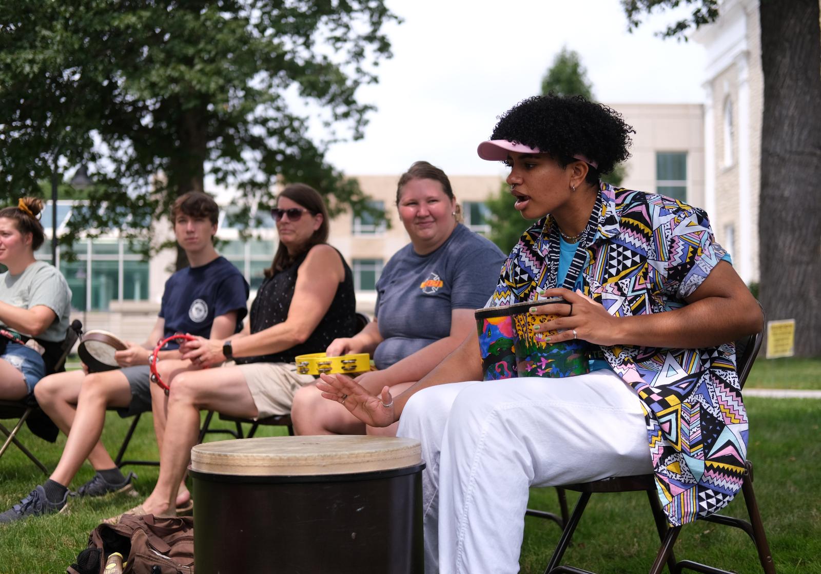 Student teaches other how to play drum