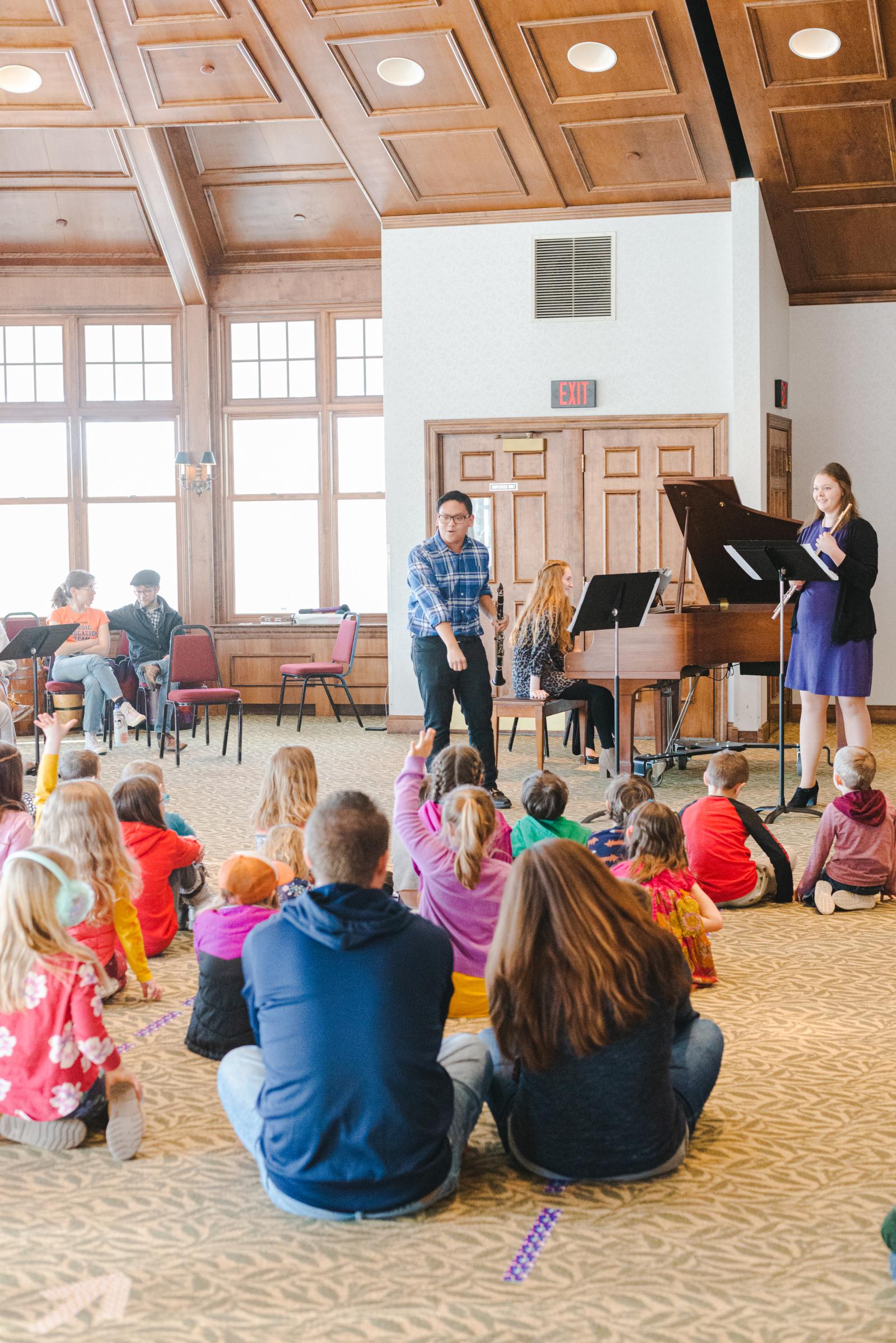 Musicans interact with seated children.