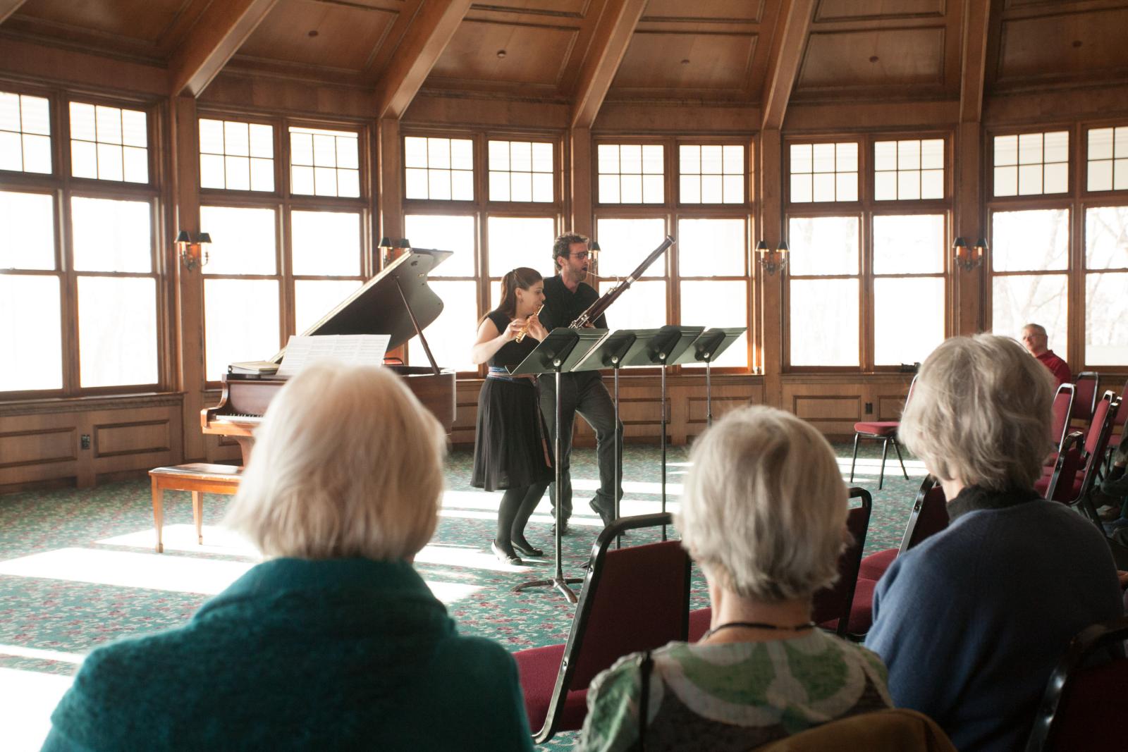 Flautist and bassonist perform for an audince.