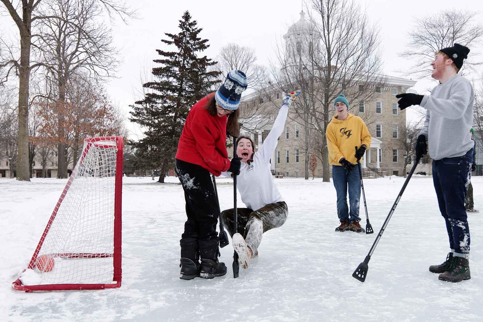 Maddy Tevonian, a sophomore, falls down as she celebrates after scoring the game-winning goal during broomball on Ormsby Lake during Winter Carnival. 