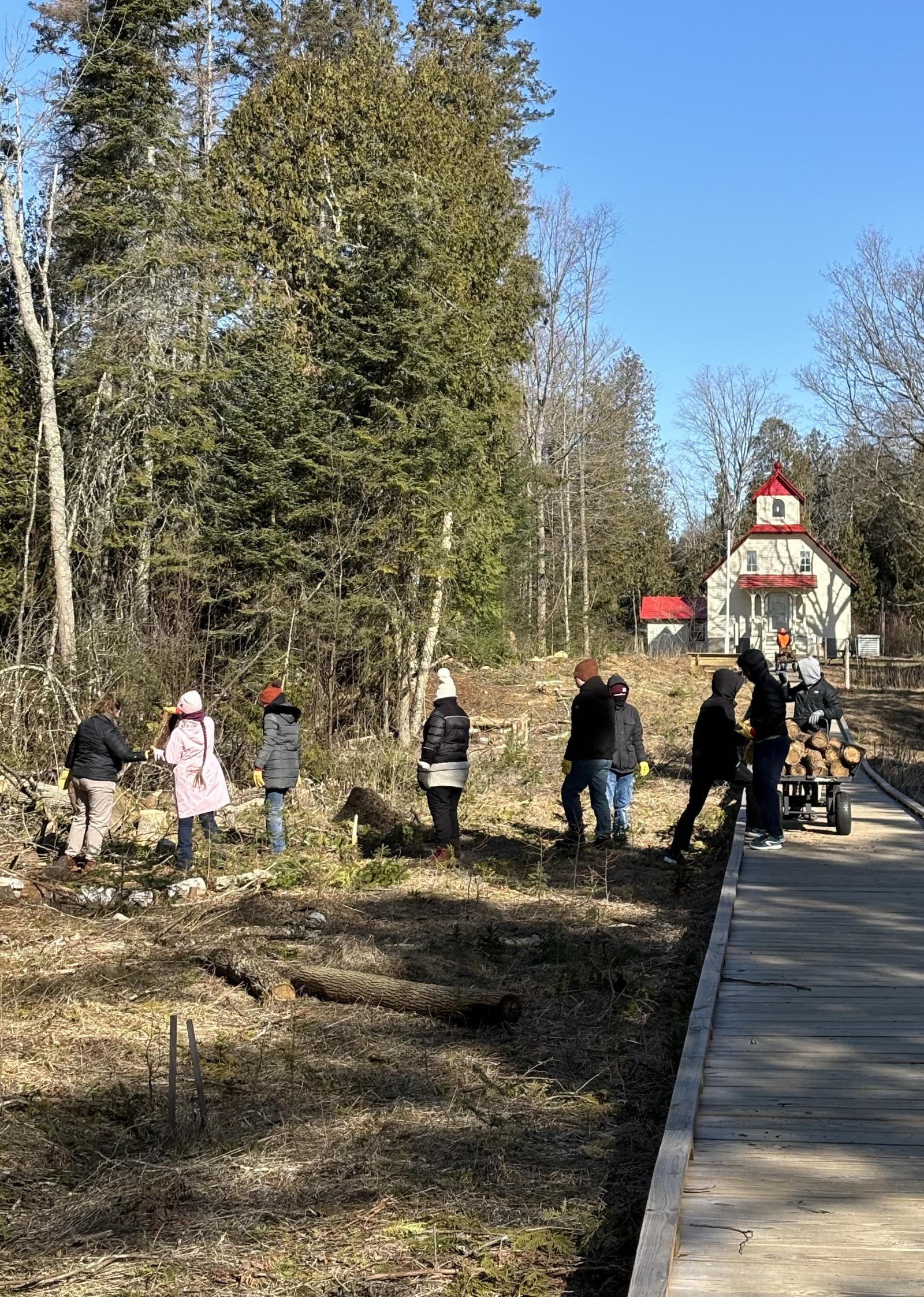 students clear debris between the Baileys Harbor Range Lights