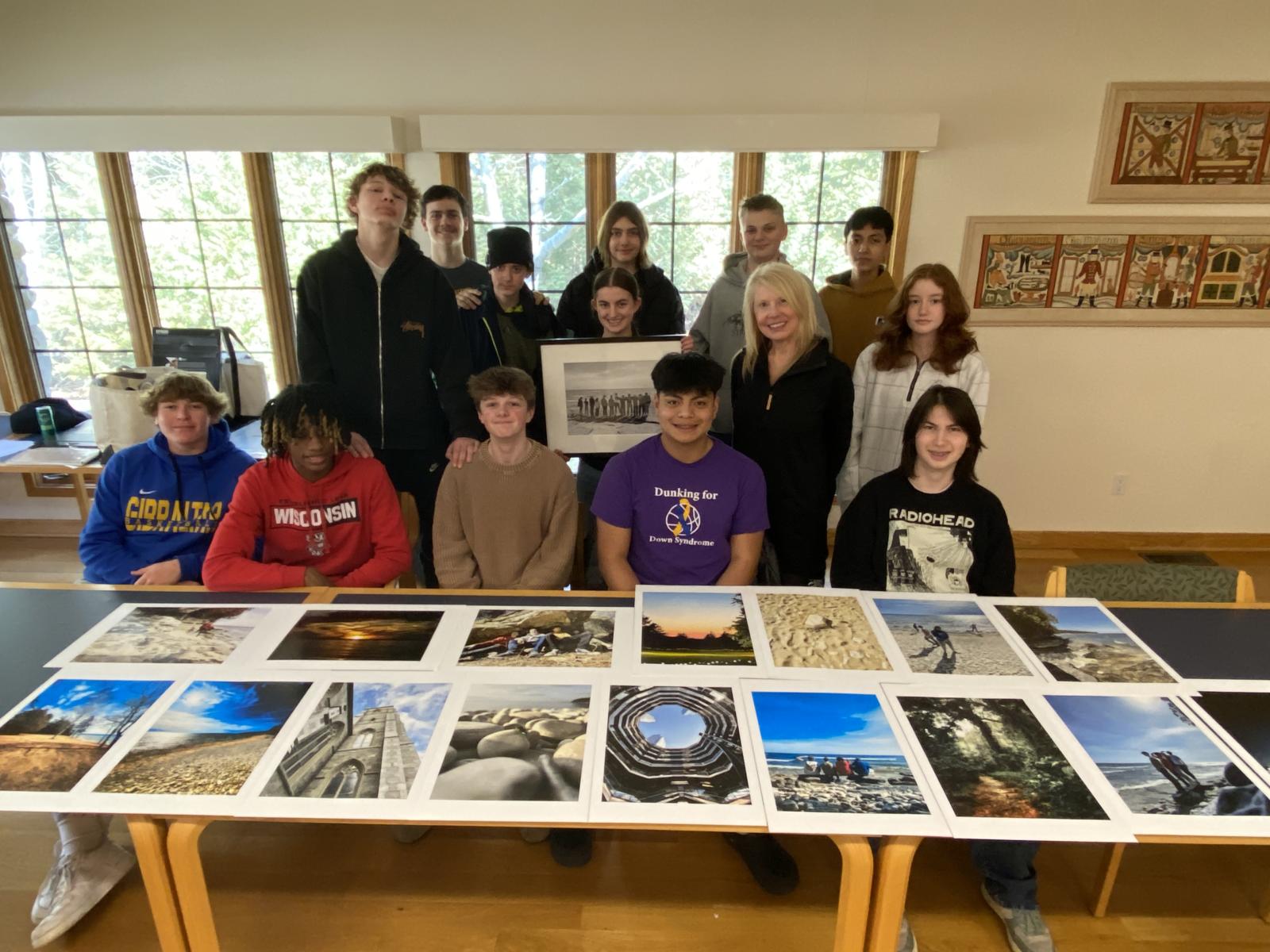 Students sit at a table with photos on it