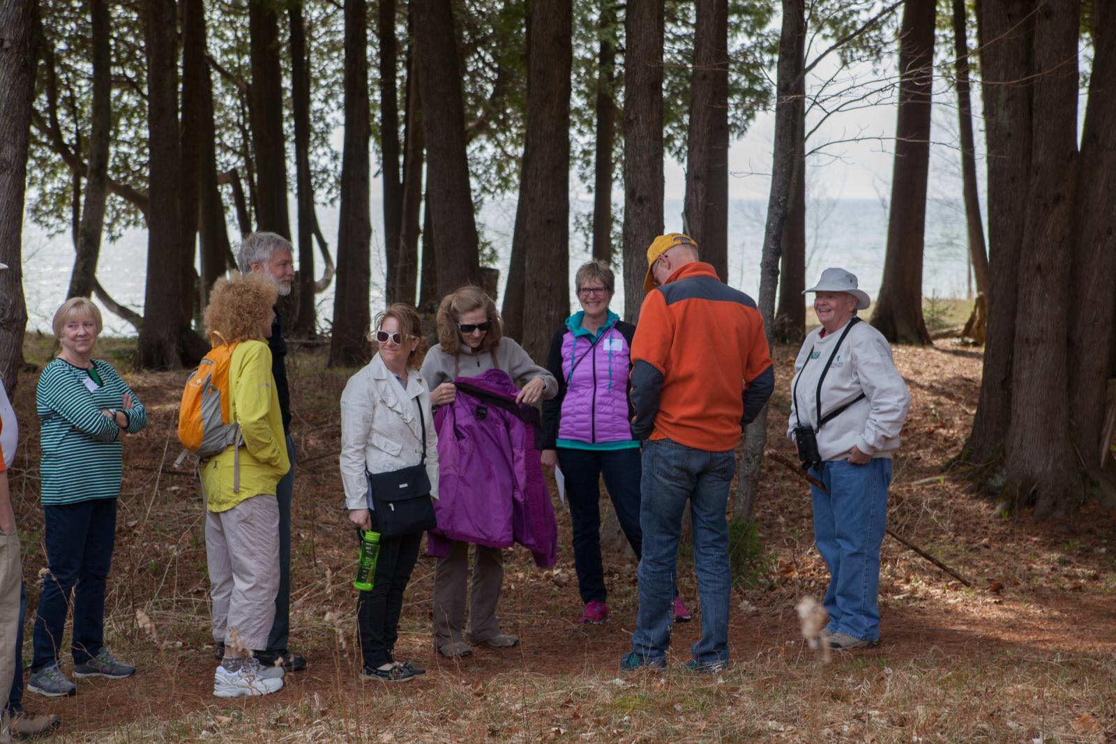 a group of hikers on a wooded trail by a lake