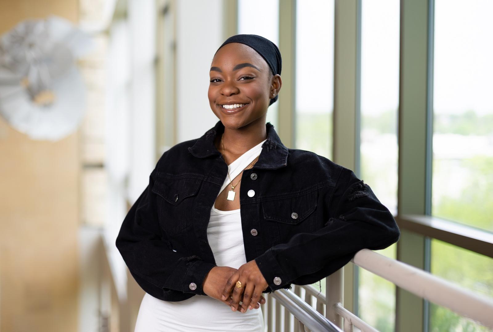 Monique Johnson poses for a portrait in front of the large windows in Warch Campus Center.
