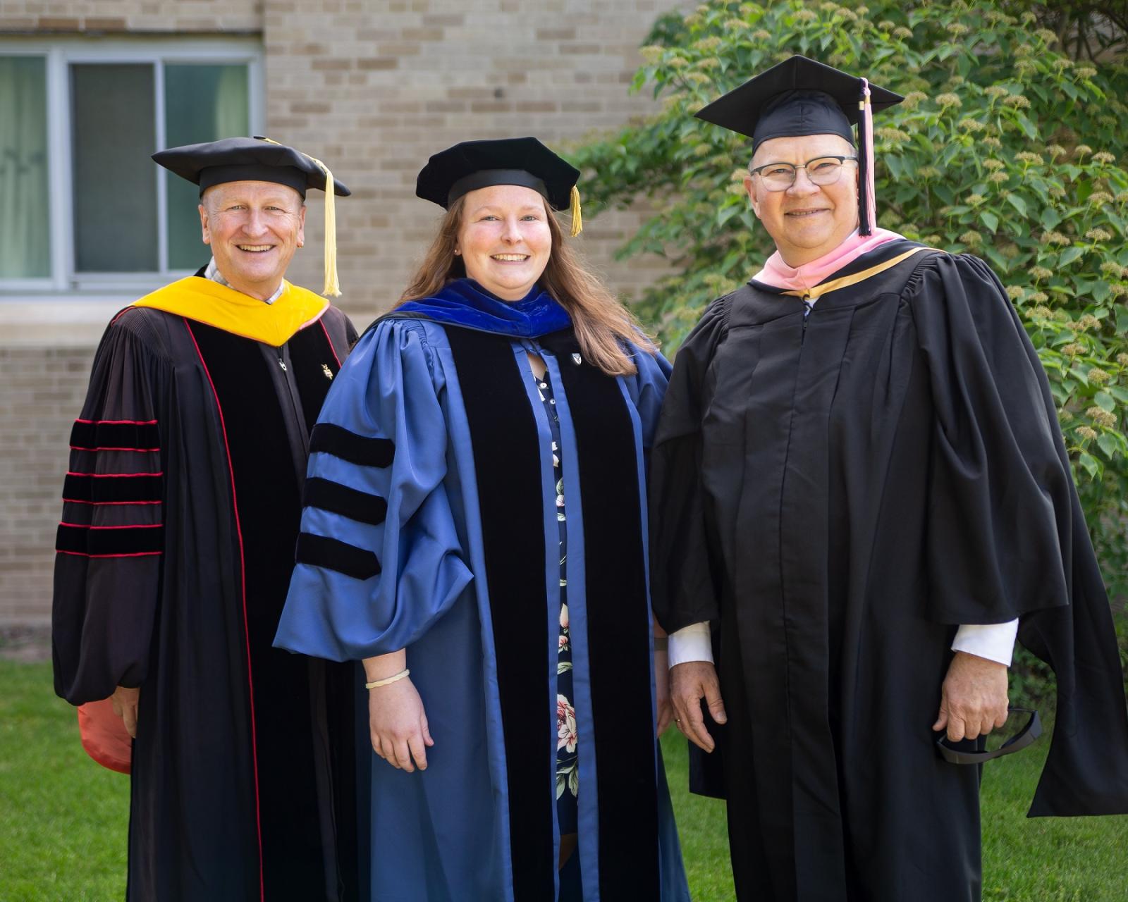Faculty award winners, dress in regalia, include (from left) Matthew Stoneking, Kelly Culhane, and Matthew Michelic.