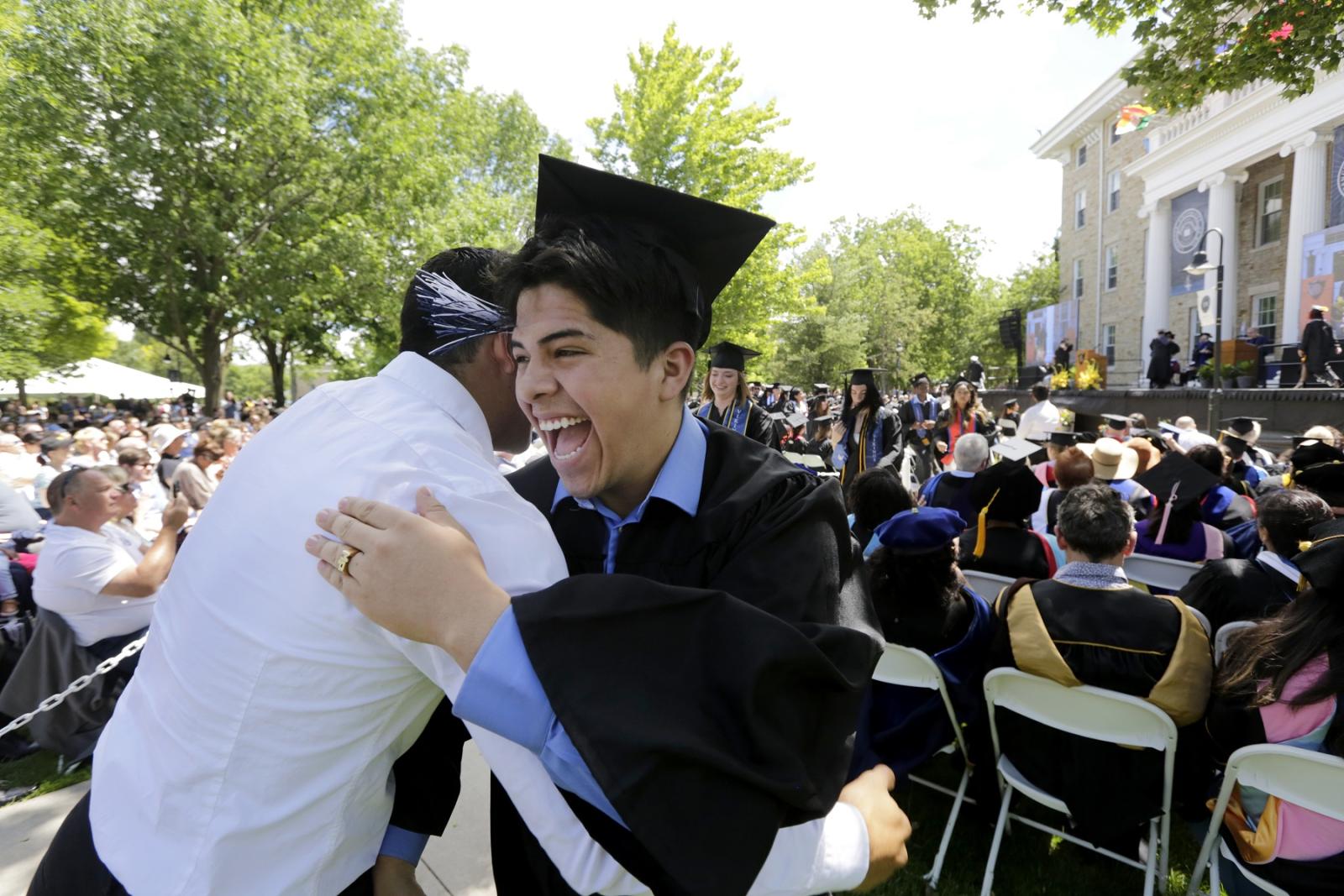 A graduate gets a hug at Commencement.