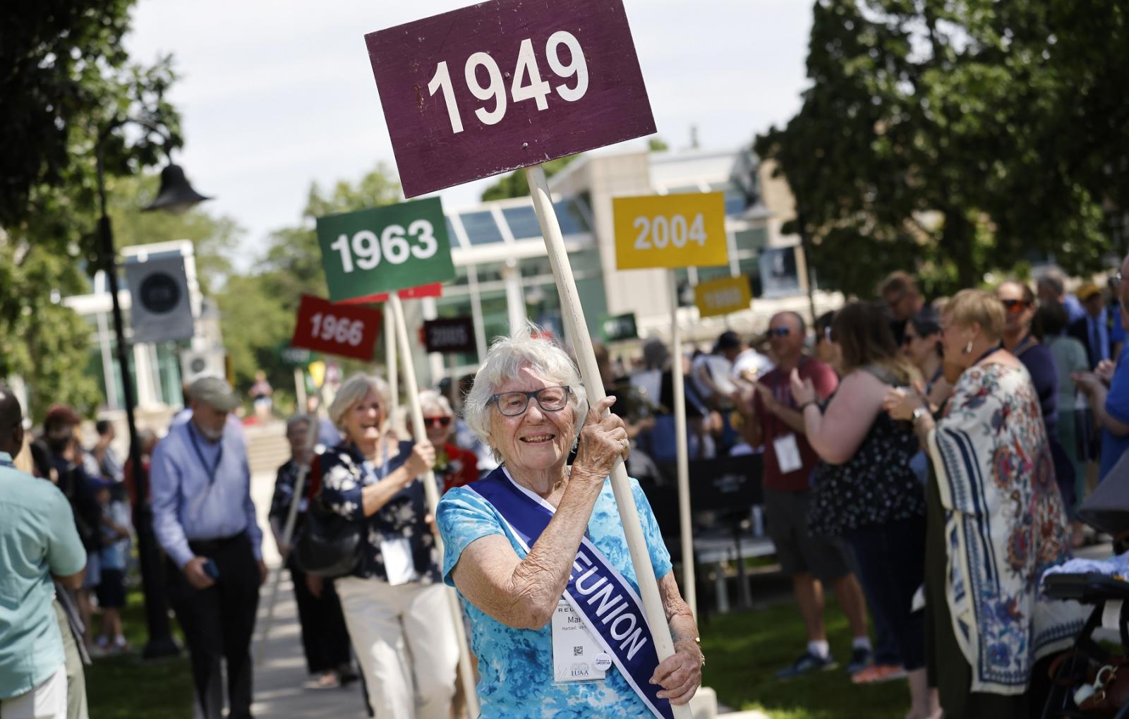 Mary Hartzell '49 holds the 1949 sign as she leads the Parade of Classes.