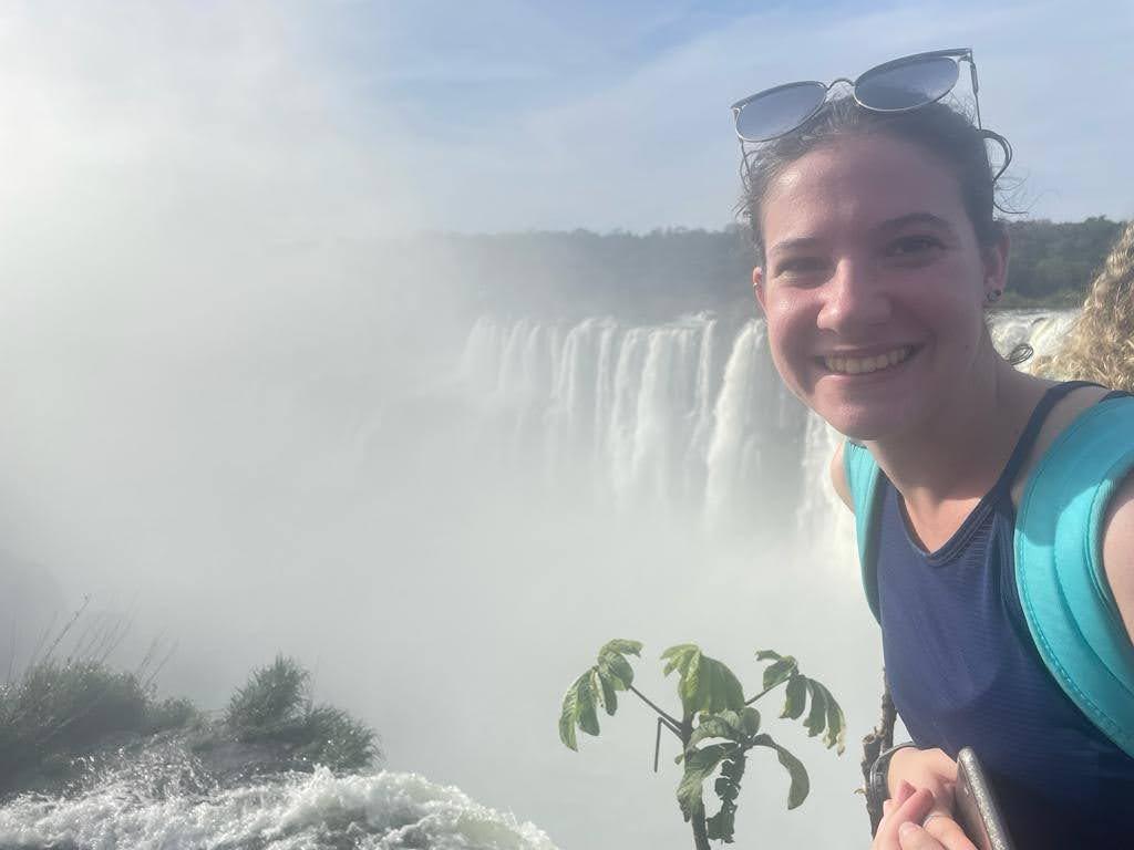 Rain Orsi poses in front of a waterfall in Argentina.