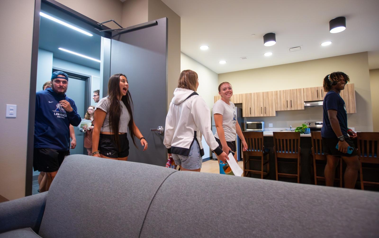 Students react as they take a tour of one of the student apartments in Fox Commons following the ribbon-cutting ceremony.