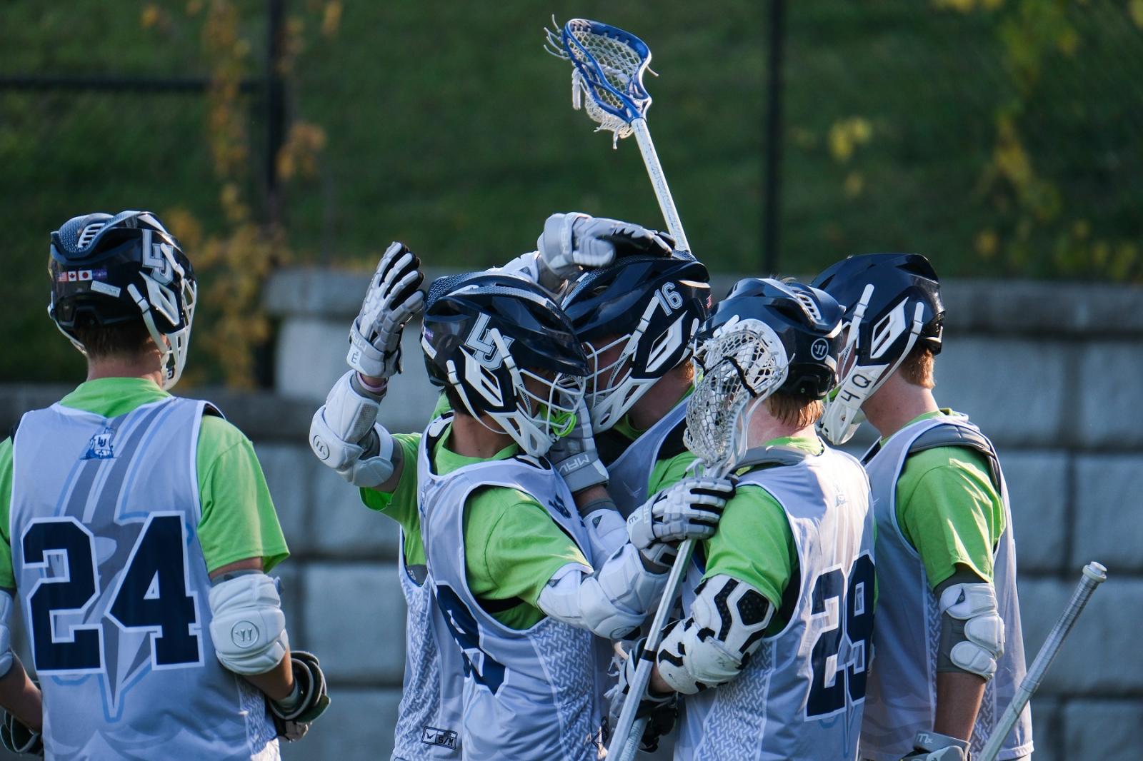 Lacrosse men's team celebrates a goal.