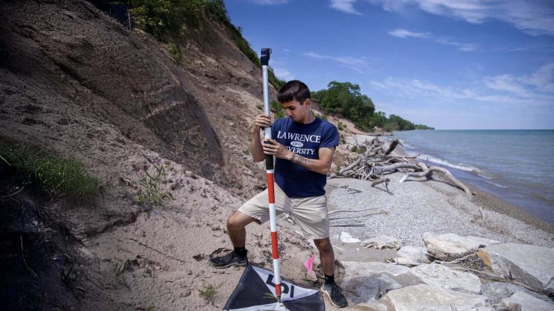 Student conducting UAV research on shore of Lake Michigan