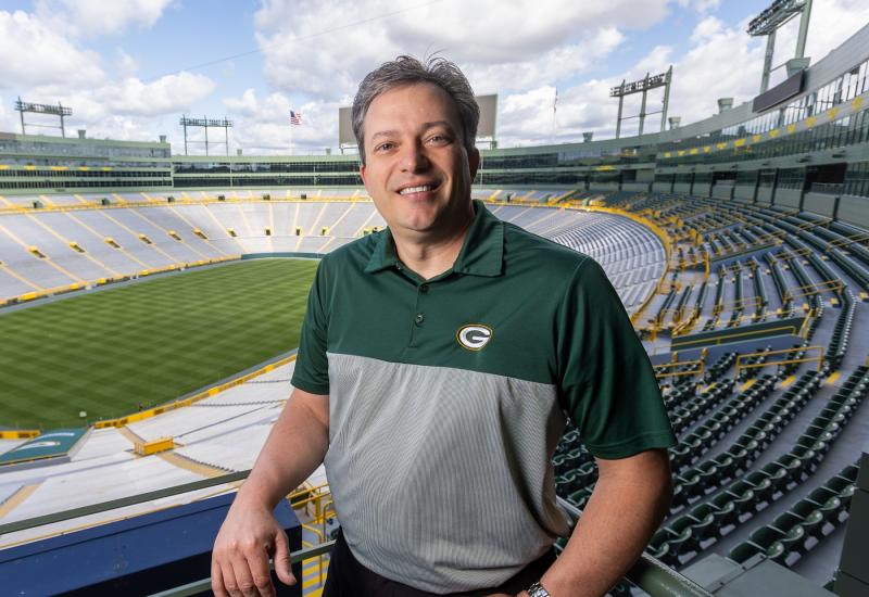 Mike Spofford '94 poses for a photo inside Lambeau Field. 