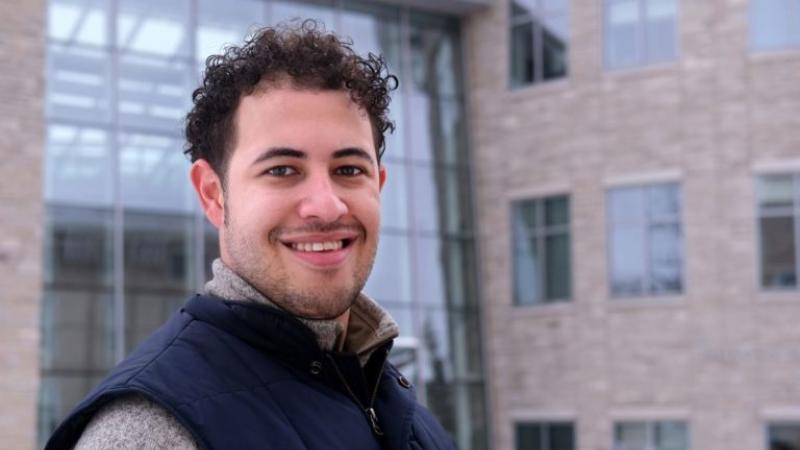 Daniel Toycen, wearing a navy blue vest, smiles at the camera.