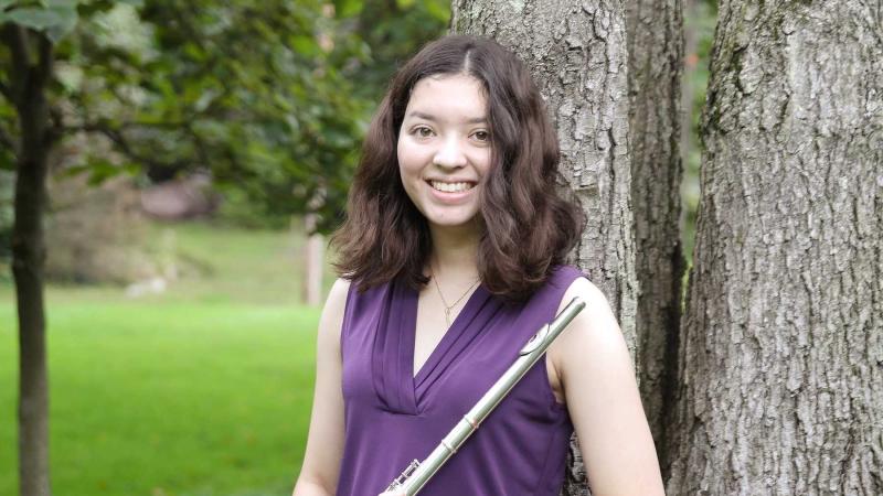 Cynthia Kaiser poses by a tree with her flute.