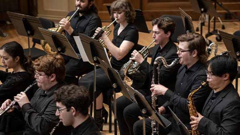 Woodwind and brass musicians in concert black play on the Chapel stage