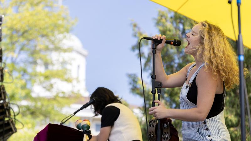 Main Hall cupola is seen in the background as a Mile of Music artist performs on Main Hall Green during the 2023 festival.