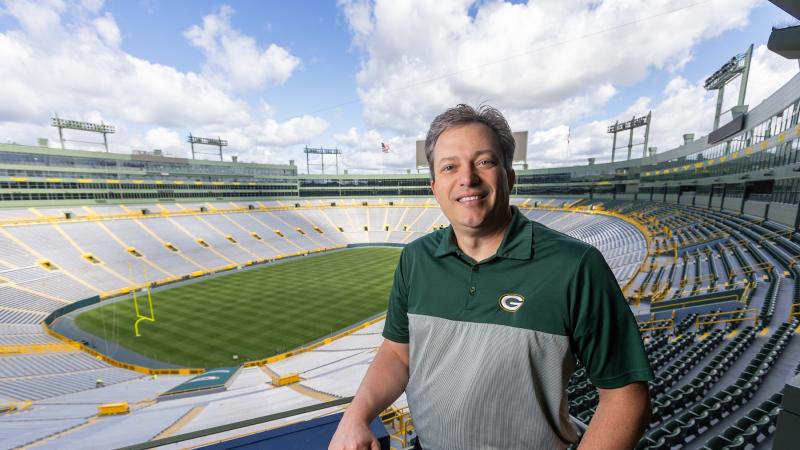 Mike Spofford '94 poses for a photo inside Lambeau Field. 