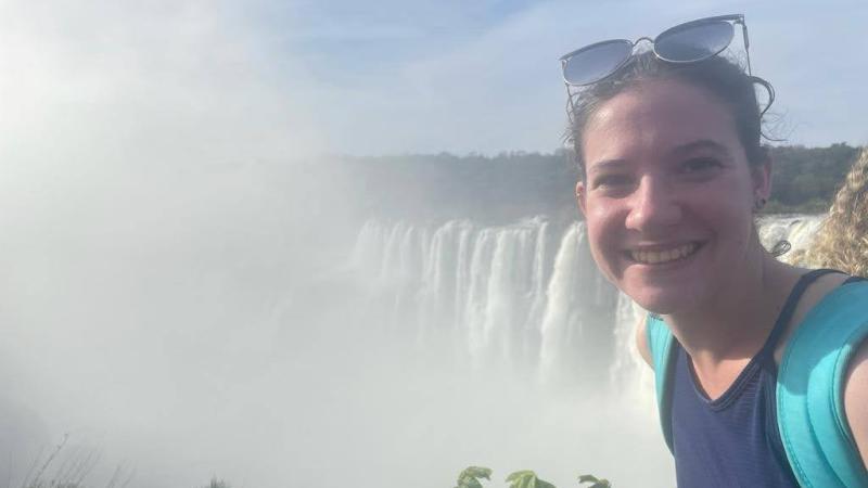 Rain Orsi poses in front of a waterfall in Argentina.