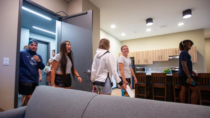 Students react as they take a tour of one of the student apartments in Fox Commons following the ribbon-cutting ceremony.