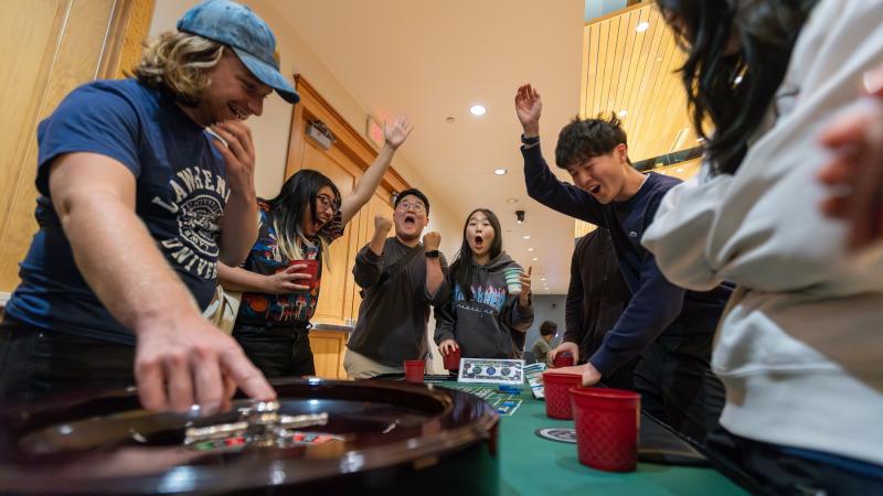 Students react with smiles and shouts during Casino Night, part of Welcome Week.