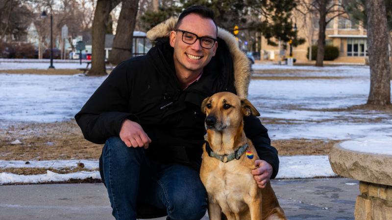 Mike Gesinski poses for a photo on Main Hall Green with his dog, Maeby.