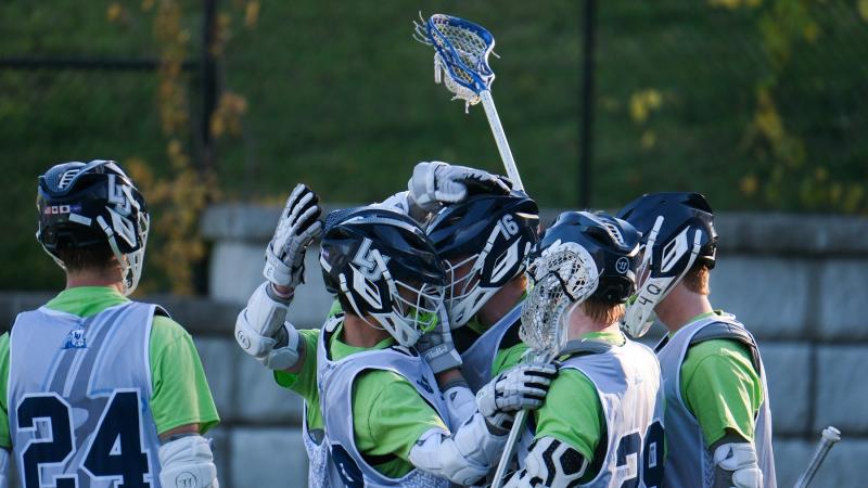 Lacrosse men's team celebrates a goal.