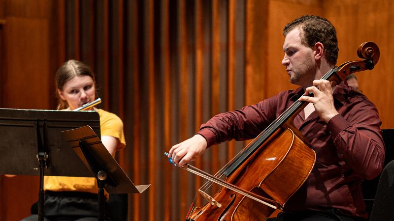 A cellist in a chamber performance with a flutist.