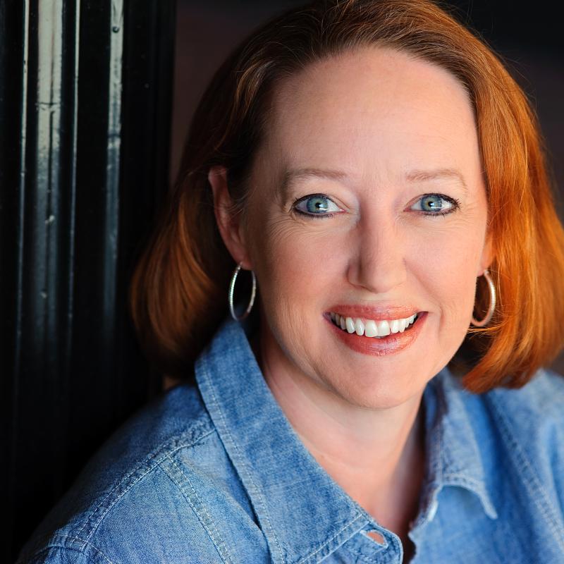 Red-haired woman sitting next to lamp post