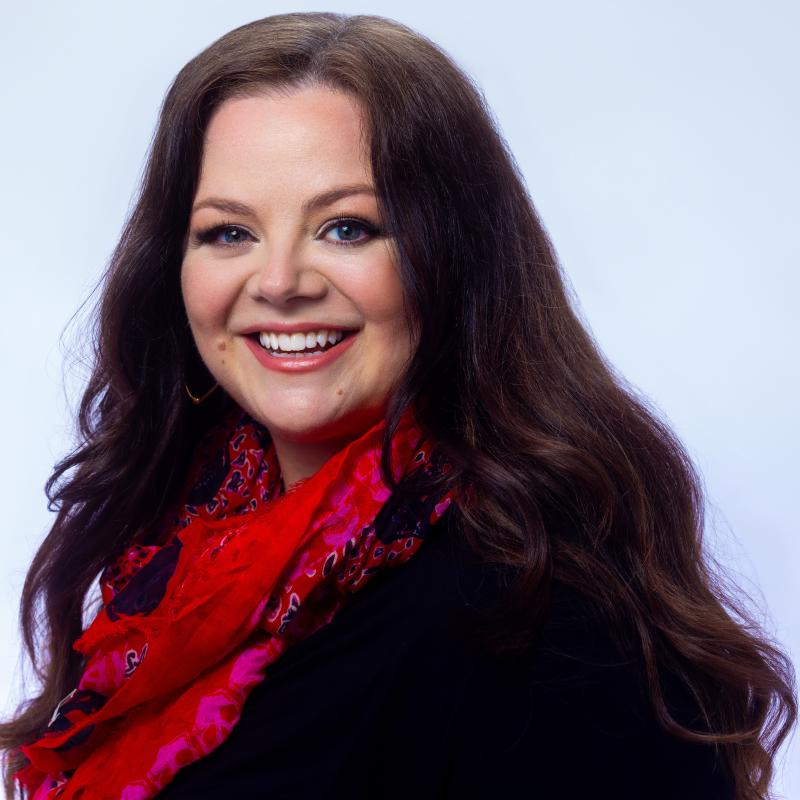 Nadje Noordhuis is smiling at the camera and wearing a red scarf