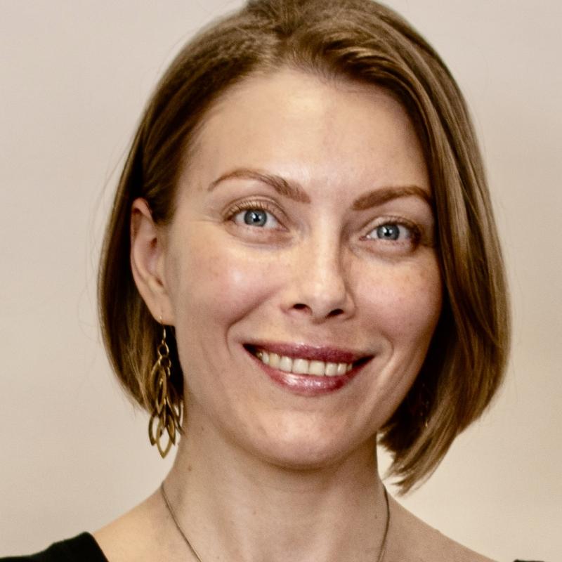 The photo picturing a head portrait of a white slavic woman in her 40s smiling at the camera