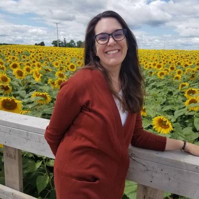 Claire standing in a field of sunflowers. 